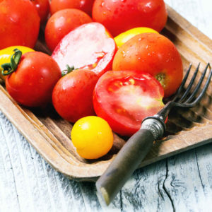 Sliced, fresh tomatoes on plate with fork