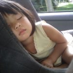 young child napping in car seat