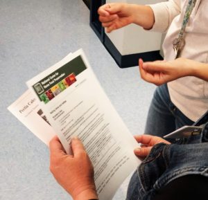 Person holding instructions from the National Center for Home Food Preservation for canning food at home
