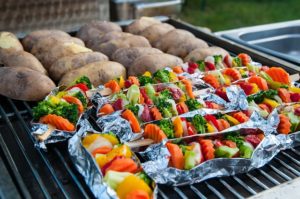 grilling potatoes on the grill with vegetables being grilling vegetables in foil