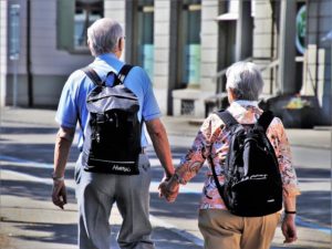 senior couple walking with backs packs