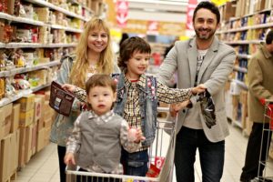 Family shopping for food with two children in the shopping cart
