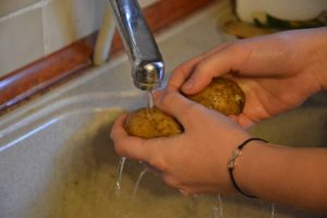 kid washing potatoes