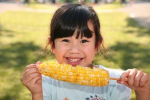 little girl eating corn on the cob
