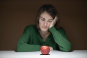 woman-in-green-sweater-sitting-in-front-of-apple