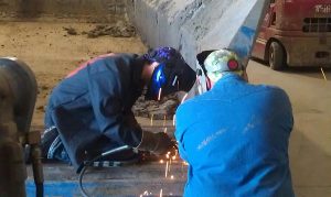 Father teaching son welding