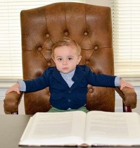 Young boy in an executive chair as the boss
