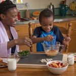 Mom and boy preparing breakfast in small portions