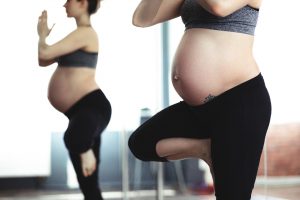 pregnant women doing yoga stand