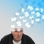 Person whose mind is disappearing in puzzle pieces