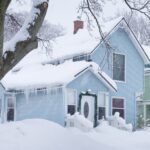 Blue family home with snow in the yard