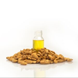 bottle of oil surrounded by almond nuts