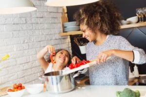 Mother cooking soup with daughter
