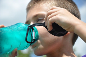 child drinking from a reusable water bottle