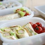 packed lunches with tomatoes, lettuces, and sandwiches