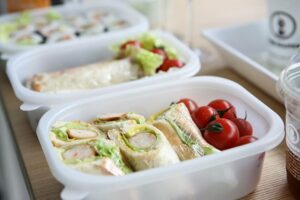 packed lunches with tomatoes, lettuces, and sandwiches