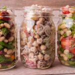 Three jars filled with a variety of bean salads.