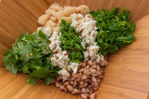 Butter beans, white beans, cilantro, parsley, chives, dill, Basil, feta Cheese, red chili flakes, vinegar and oil.