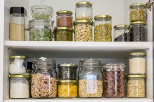 two pantry shelf's filled with dry foods in glass jars 