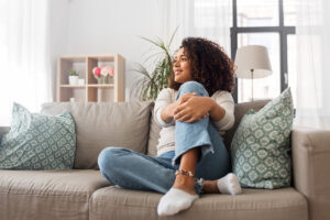 Woman sitting on couch, America-saves-saving-automatically