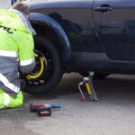 Emergency worker changing a flat tire.