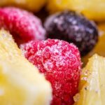 pile of frozen pineapple, raspberries and blueberries