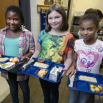 Three students with school lunch