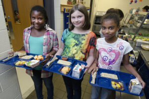 Three students with school lunch