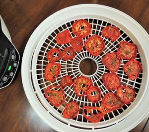 Dehydrator with timer, temperature control and fan. Dehydration tray showing dried tomatoes