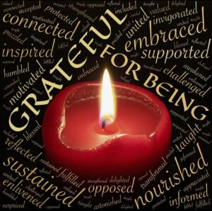 Red candle surrounded by words of gratitude