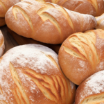 Several loaves of crusty artisan bread in different shapes, round and long.