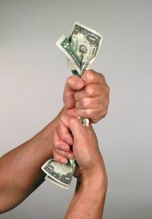 Person squeezing money to show how tight money is