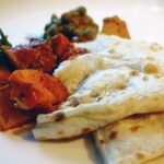 Flatbread served with potatoes, tomatoes, and lentils