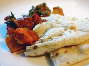 Flatbread served with potatoes, tomatoes, and lentils