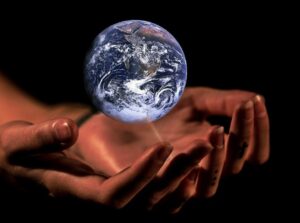 Picture pf two hands holding a blue and white world globe.