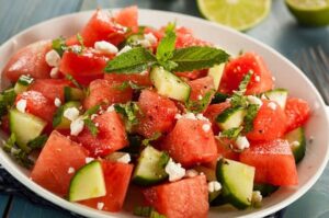 Watermelon salad with cucumber, feta cheese, basil, and mint with honey, lime juice and olive oil dressing