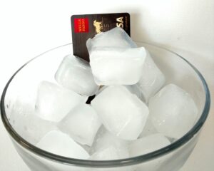 A credit card sitting in a bowl of ice to freeze