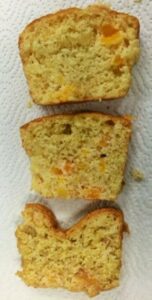 3 slices of quick breads demonstrating leavening. The bottom one shows a dent going down towards the bottom of the slice meaning incorrect leavening. The middle slice shows adjustments in leavening agents. The top slice shows adjustments in leavening and baking temperature.