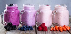 Four jars filled with berry smoothies.