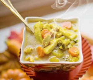 Bowl of steaming chicken noodle soup.