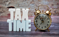The words Tax Time in blocks along with an alarm clock.
